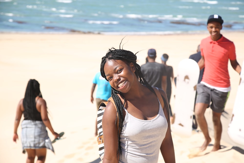 girl smiling wearing white tank top in the beach during daytime