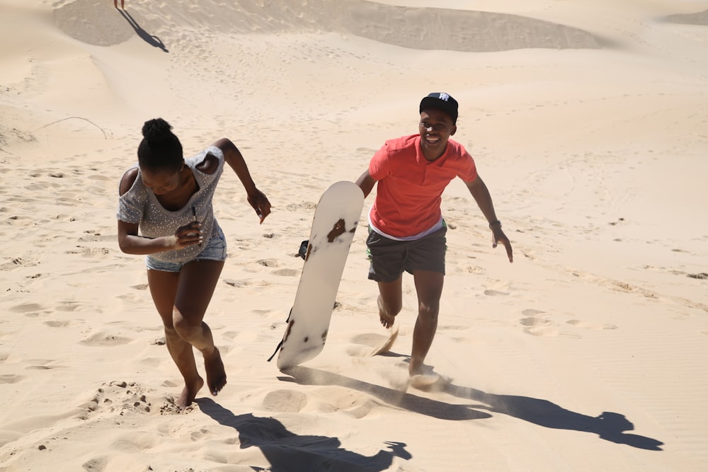 man and woman running on sand