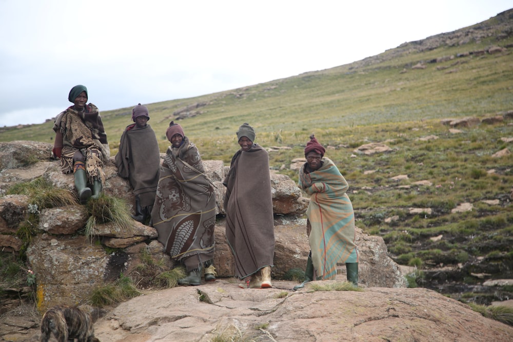 people sitting and standing on rock