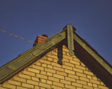 Close-up of bushfire-rated cladding on a brick veneer suburban house under bright sunlight.