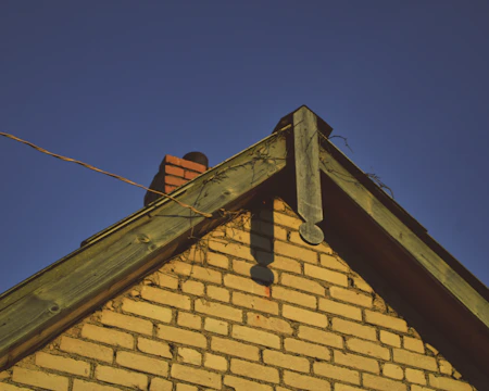 Close-up of bushfire-rated cladding on a brick veneer suburban house under bright sunlight.