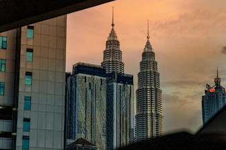 A stunning aerial view of the twin towers of BPTP Skynest piercing the skyline at sunset.