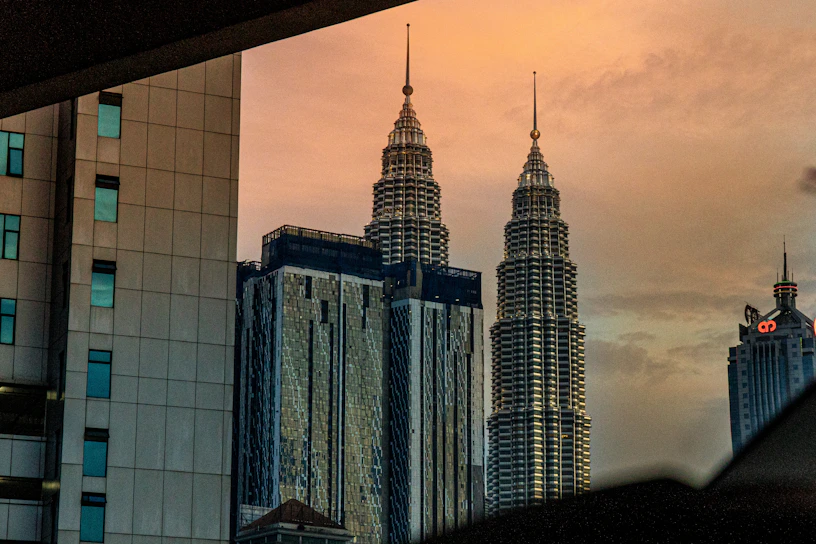 A stunning aerial view of the twin towers of BPTP Skynest piercing the skyline at sunset.