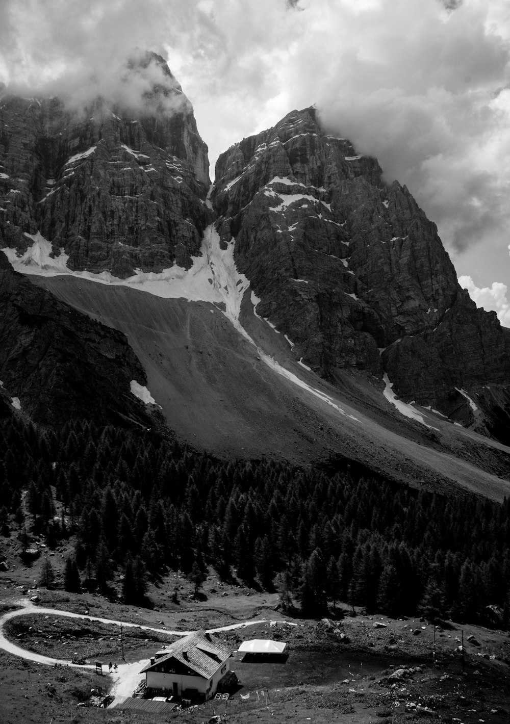 grey scale photography of mountain under white clouds