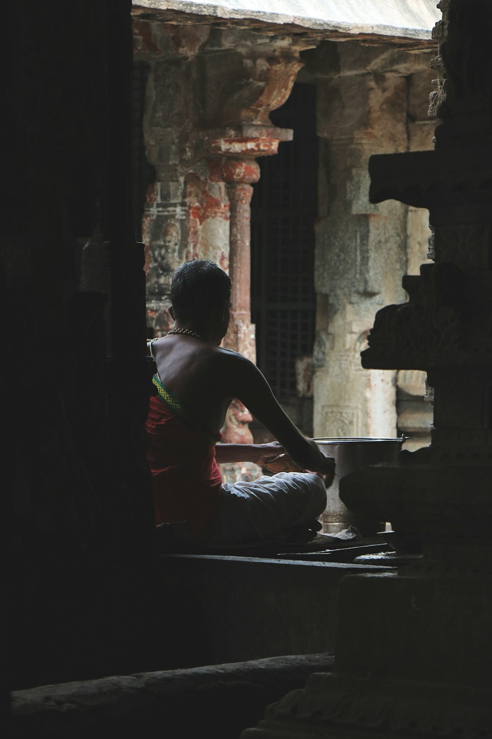 a person sitting on a ledge in a building