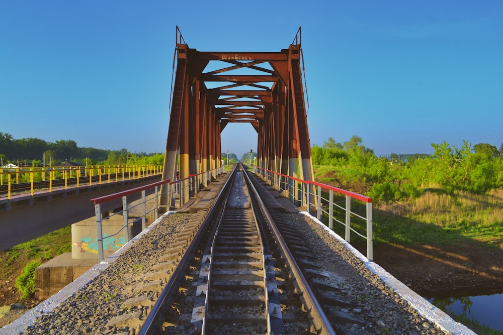 train tracks on red concrete bridge during daytime