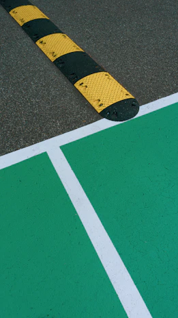 Close-up of a sturdy speed breaker installed on a city road with clear yellow and black markings.