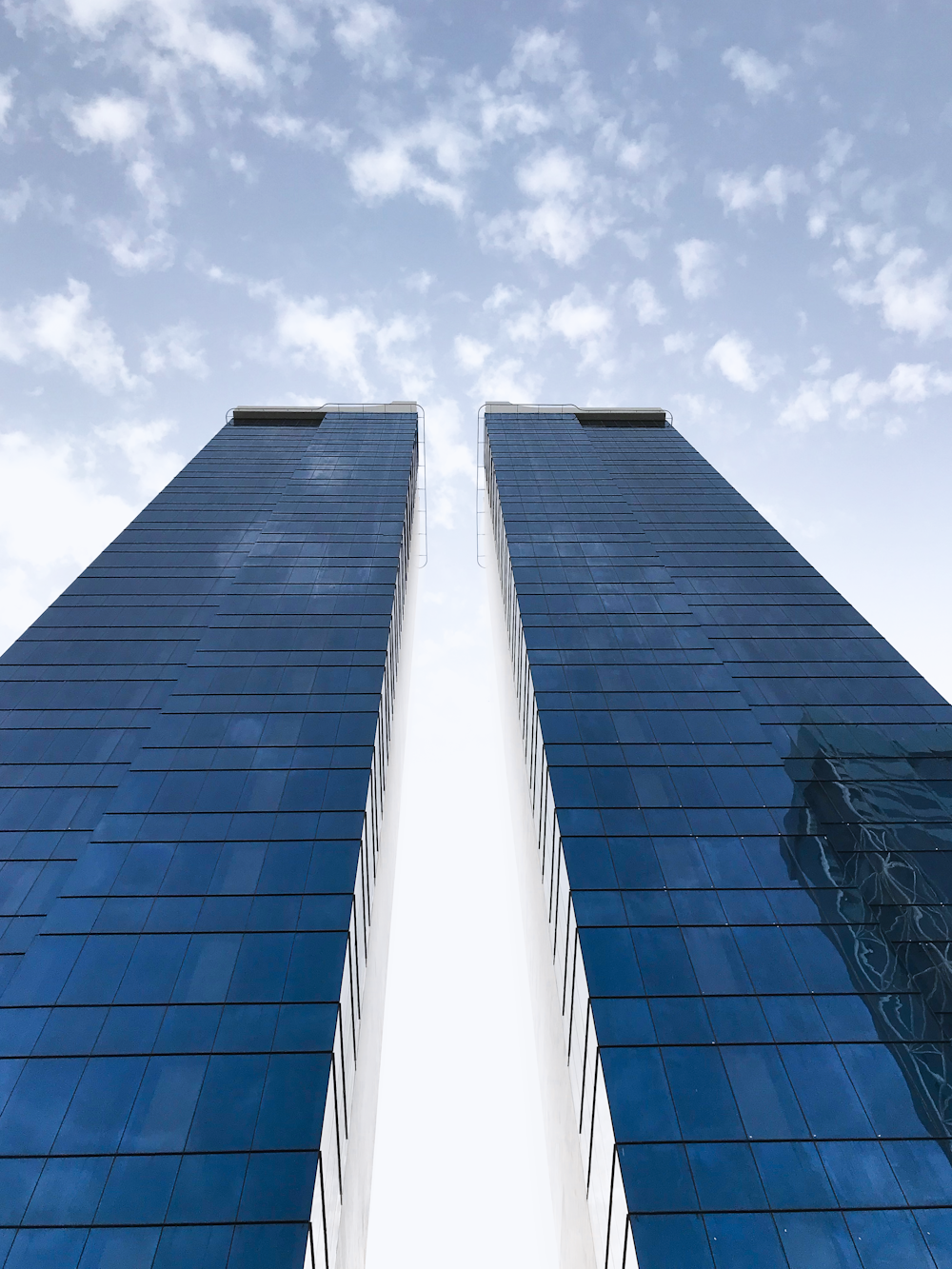 low angle photo of two blue buildings during daytime