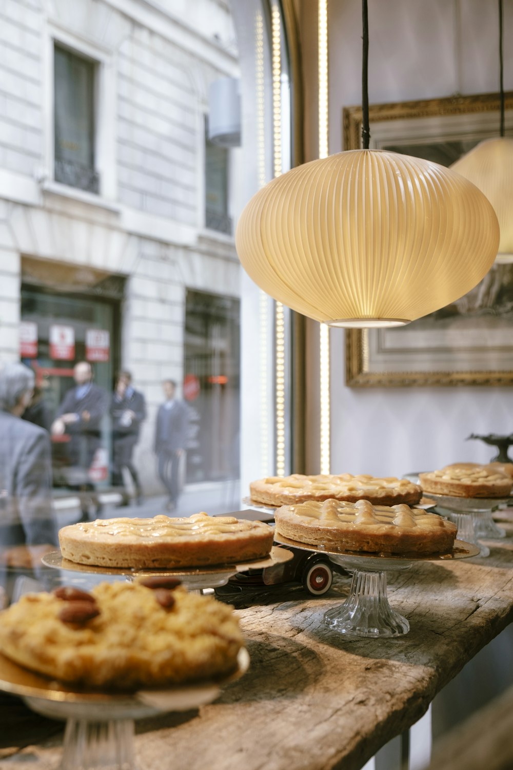 round white pendant lamp above assorted cakes on display