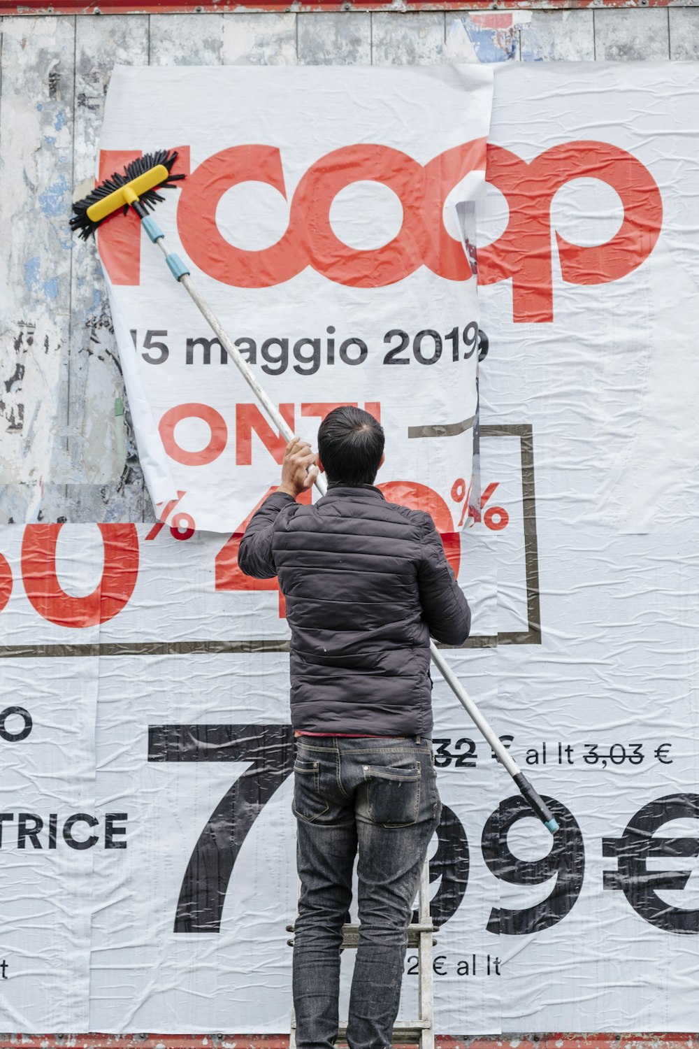 man in gray jacket brushing RCoop signage