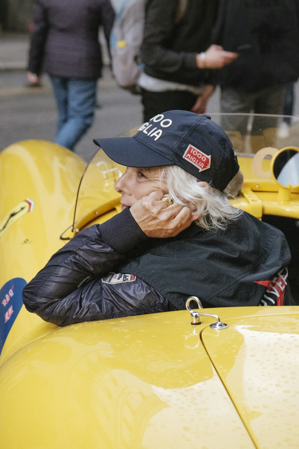 close-up photo of person sitting on yellow Ferrari car