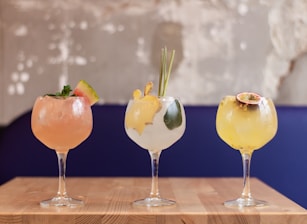 three clear glass goblet with assorted martini