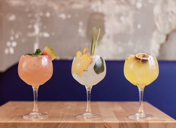 three clear glass goblet with assorted martini