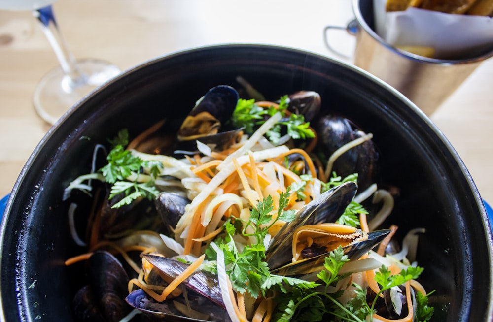 shallow focus photo of mussel dish on black pot