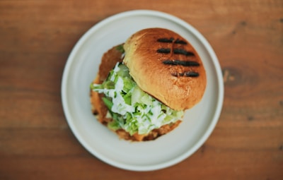 Close-up of a freshly made sandwich with melted cheese and fresh lettuce.