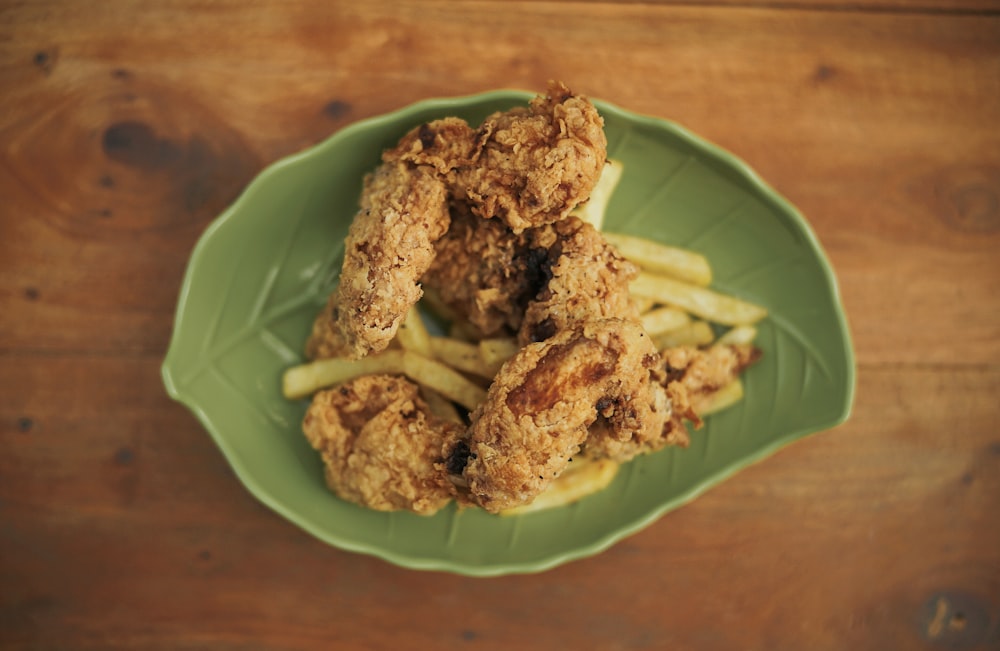 fried chicken and fries in green leaf plate