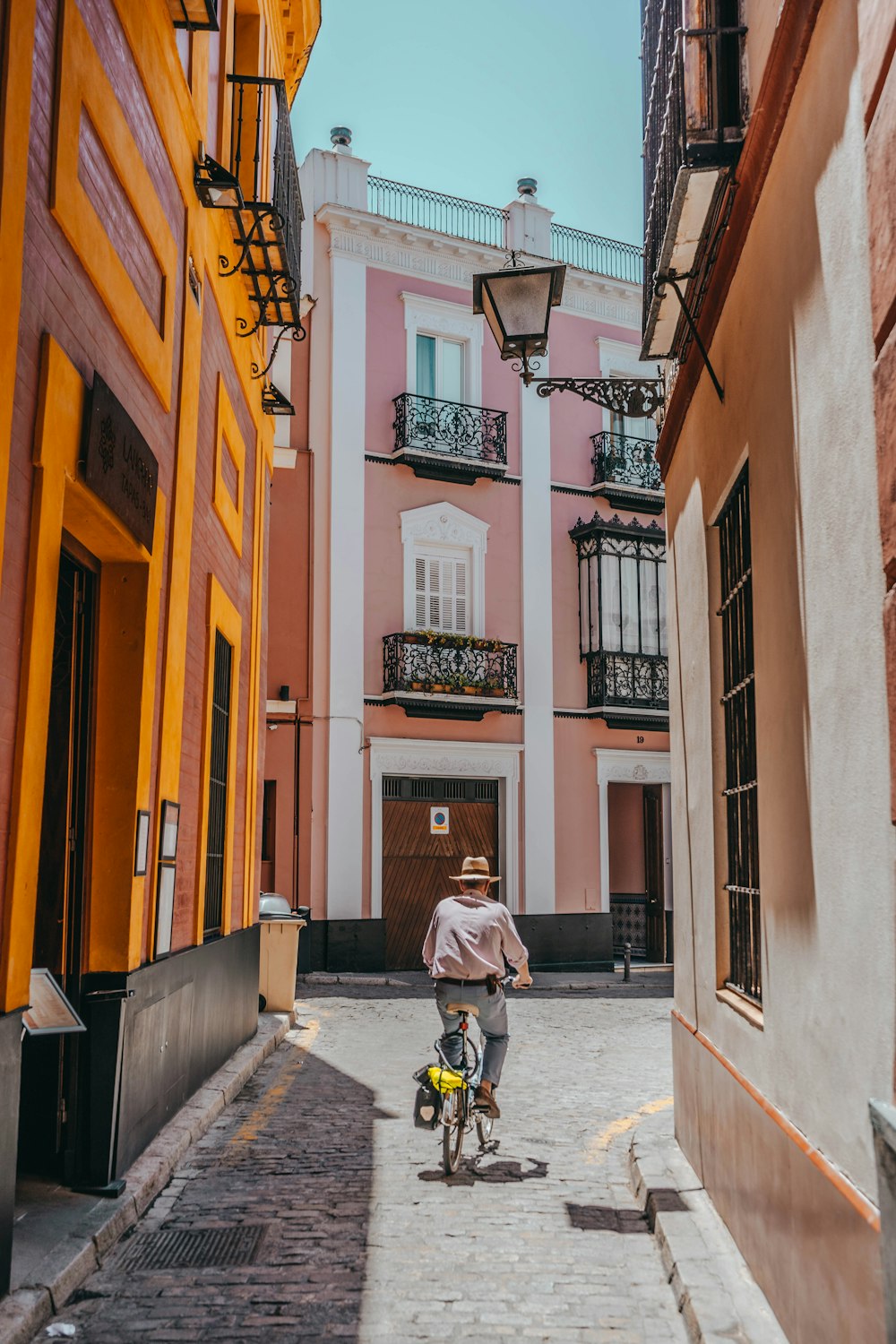 person riding bike between buildings