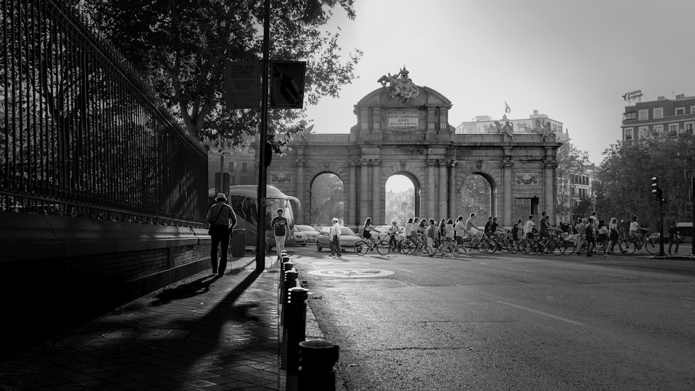 grayscale photo of person walking on sidewalk