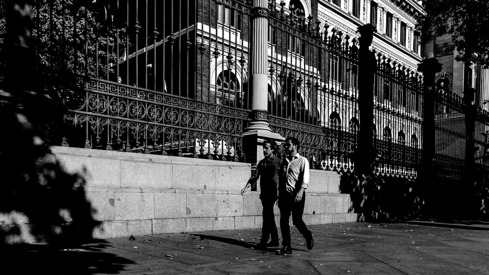 two men walking near gate