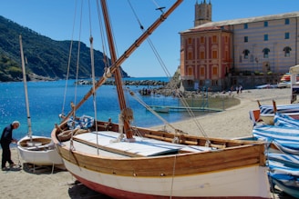 brown and white wooden boat on shore during daytime