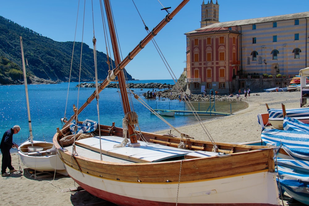 brown and white wooden boat on shore during daytime