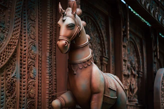 Artisan painting delicate details on a traditional Kondapalli horse figurine.