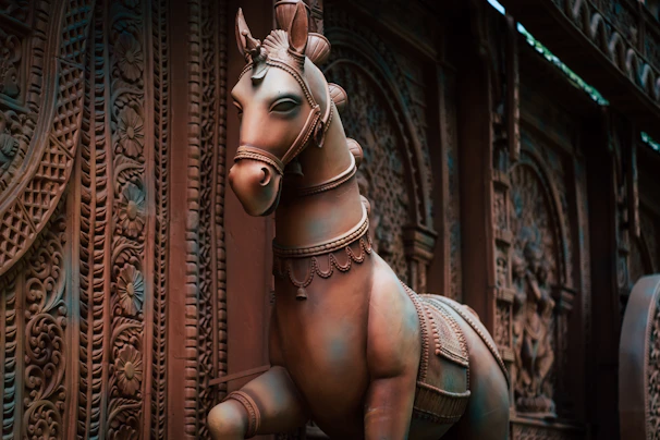 Artisan painting delicate details on a traditional Kondapalli horse figurine.