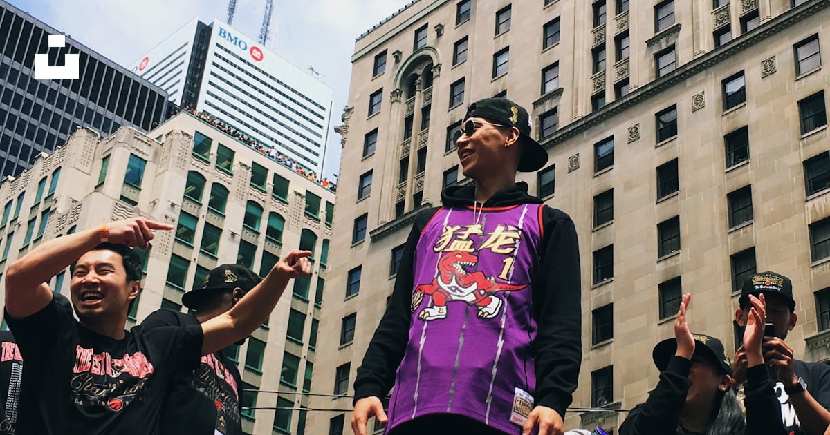 Smiling \Jeremy Lin in Raptor uniform atop of vehicle by men during ...