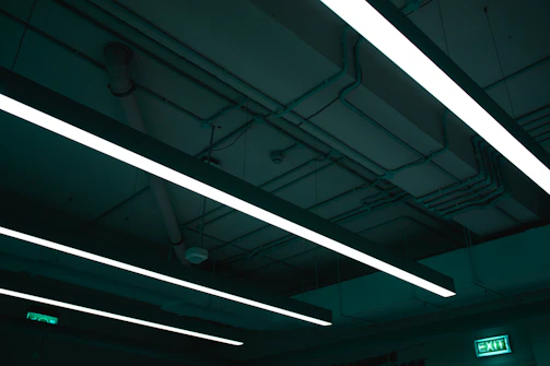 An industrial emergency light in action, illuminating a dim warehouse aisle during a power outage.