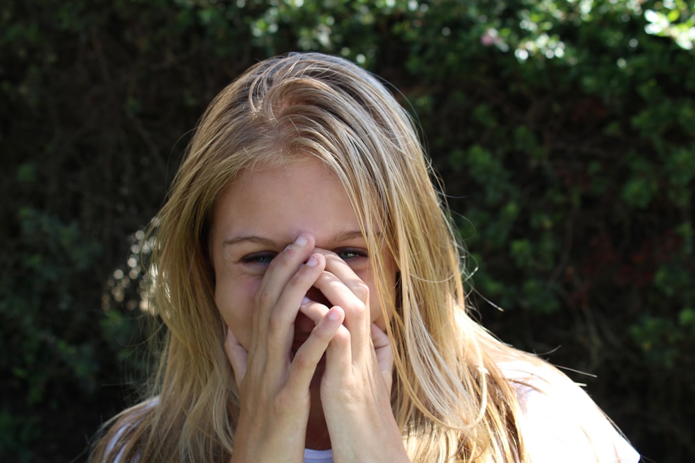 woman covering face with both hands