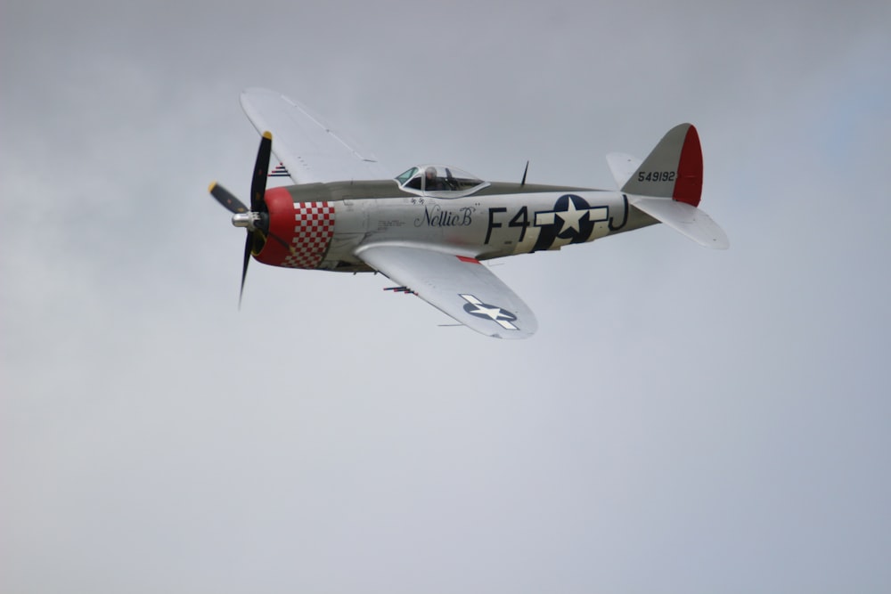 gray and red army F4 plane in flight