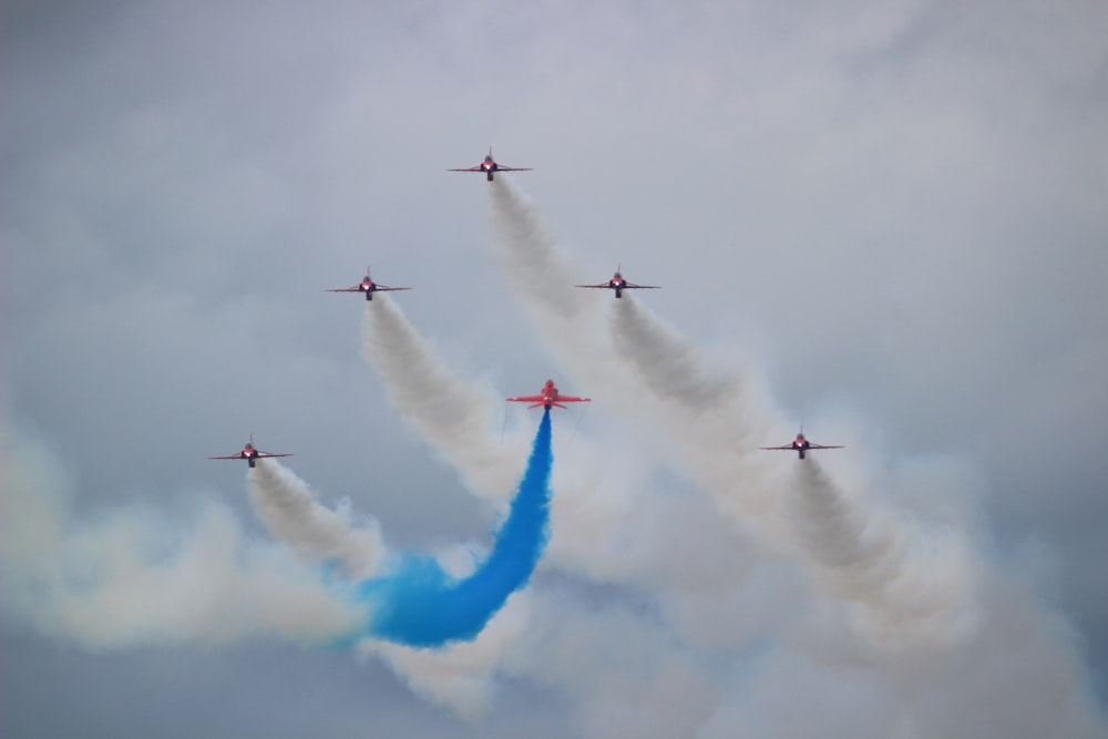 six planes leaving a white and blue smoke trail