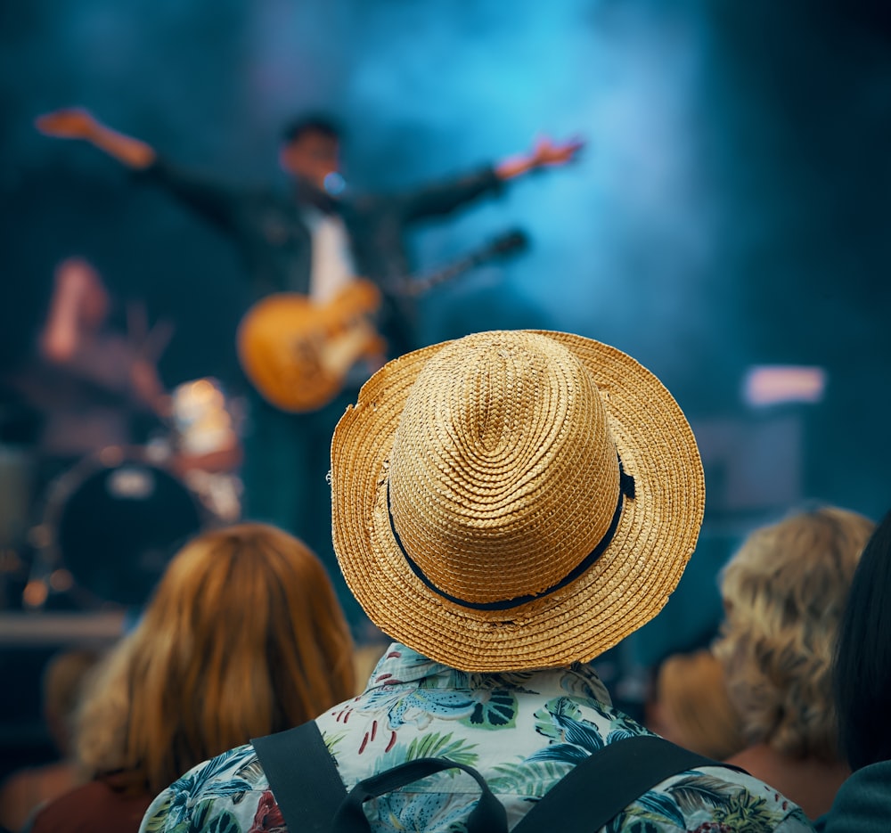 군중 앞에서 무대에 서 있는 기타를 든 남자