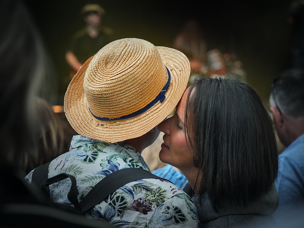 mulher sussurrando na orelha direita do homem com chapéu fedora