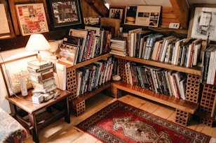 assorted books in shelf near lighted table lamp