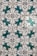 A series of ornate tiles with a repeating floral pattern featuring teal and black decorative motifs against a white background. Each tile displays a symmetrical design, creating a uniform look across the entire surface.