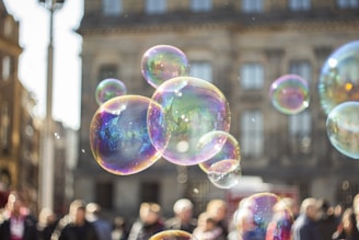 Close-up of bubbles floating in the air with joyful faces in the background.