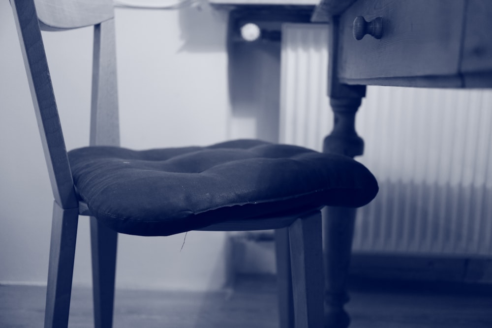 Chaise en bois avec coussin d’oreiller capitonné près du bureau