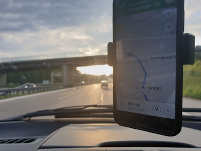A detailed route plan displayed on a tablet with a truck on the highway in the background.