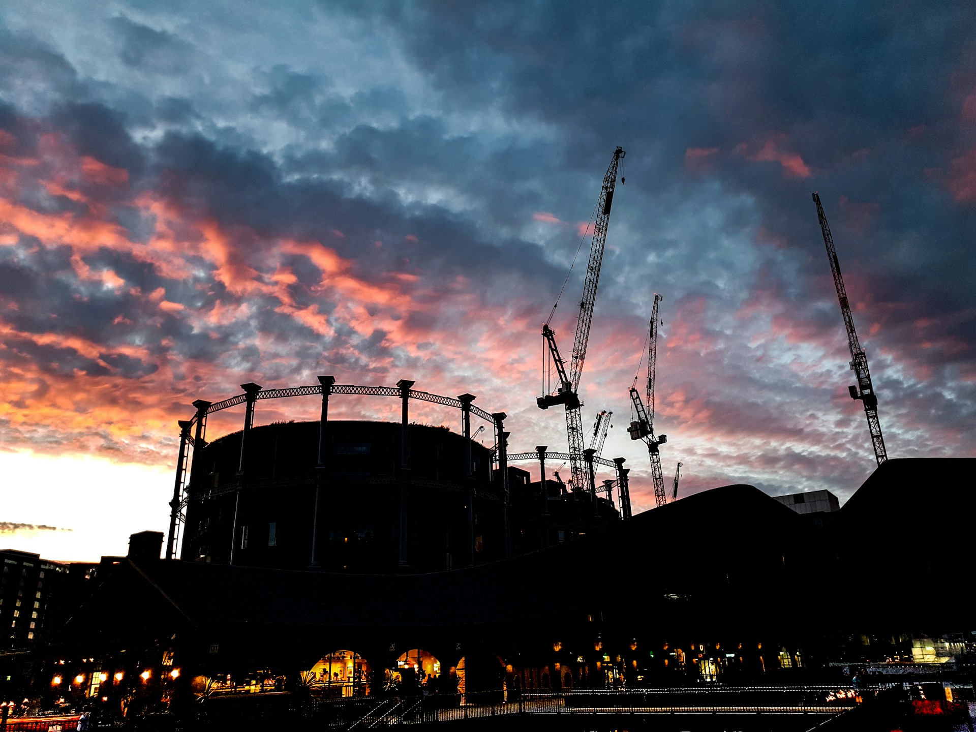 high-rise buildings showing industrial crane under blue and orange skies