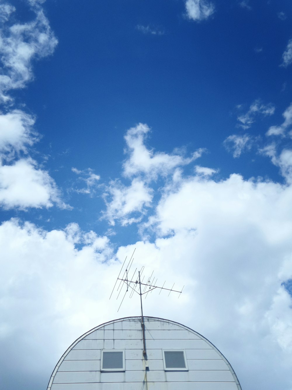 grey antenna on top of white house