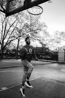Action shot of a player performing a basketball trick on an outdoor court
