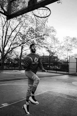 Action shot of a player performing a basketball trick on an outdoor court