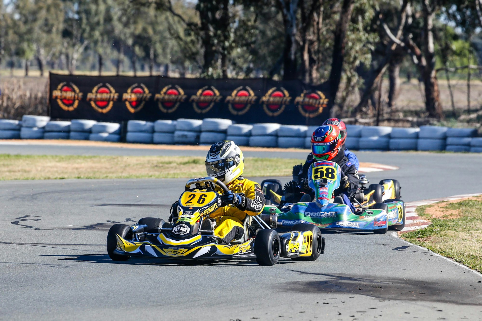 2 people racing in go-karts on an outdoor track