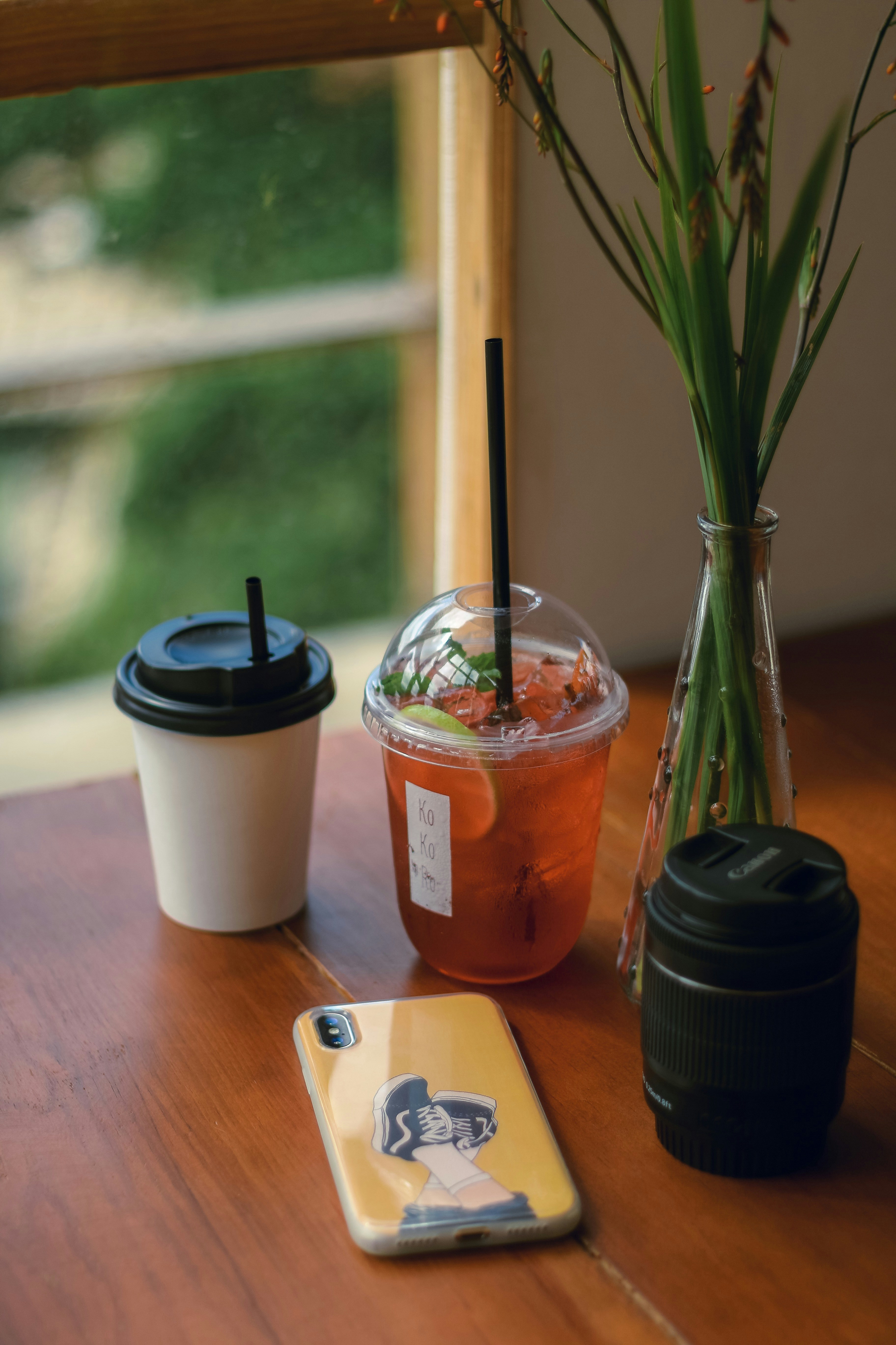 two cups of drinks on table by the window