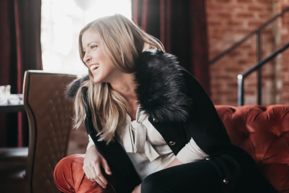 woman laughing and sitting on sofa