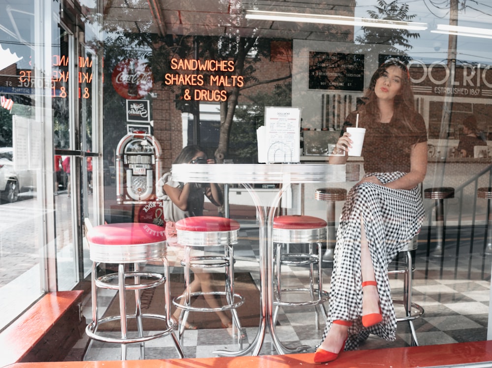 woman sitting on bar stool inside sandwiches shakes malts and drugs