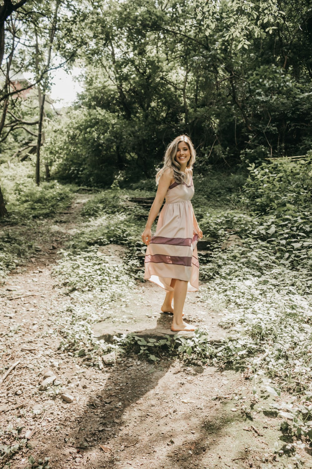 woman in beige walking in the woods