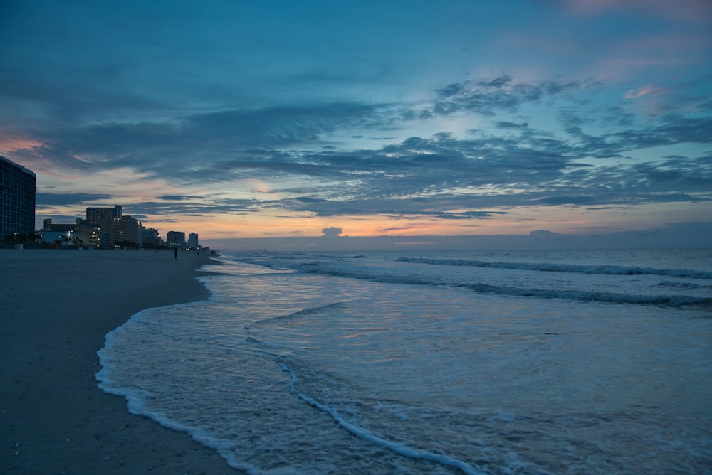 cielo naranja y azul al atardecer sobre la playa