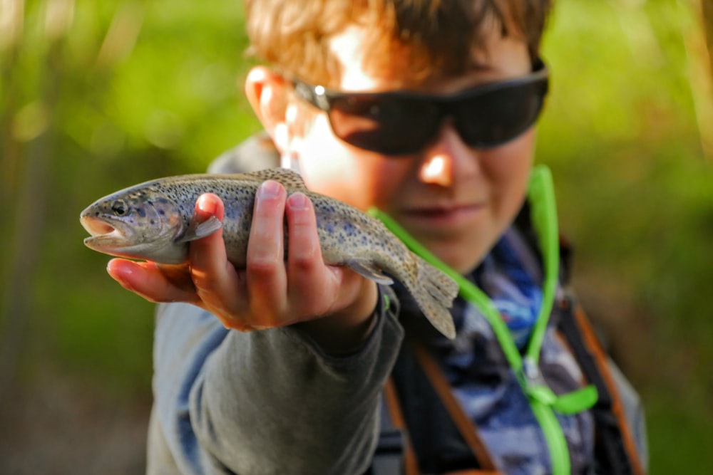 man holding brown and black fish